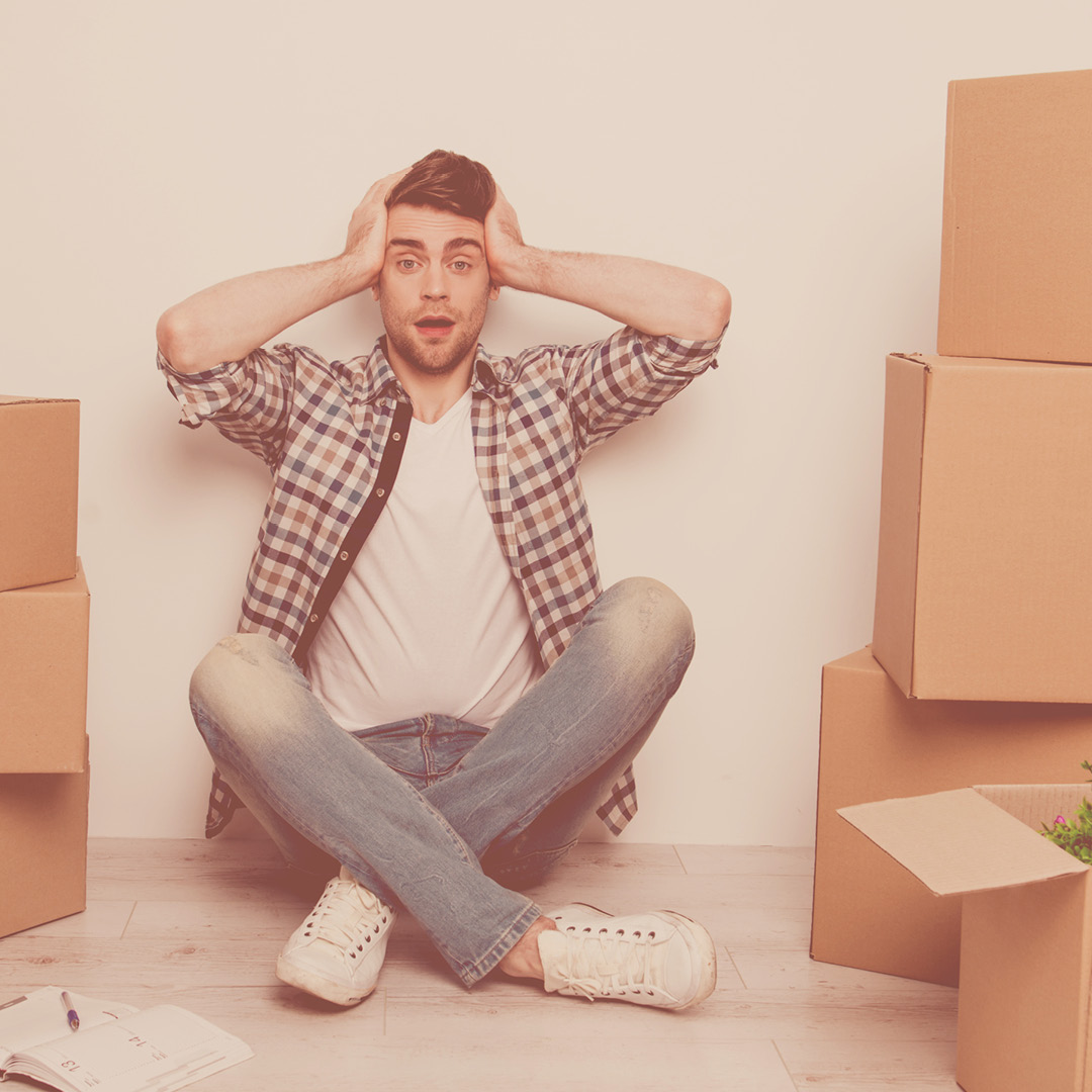 Man sitting on floor next to moving boxes