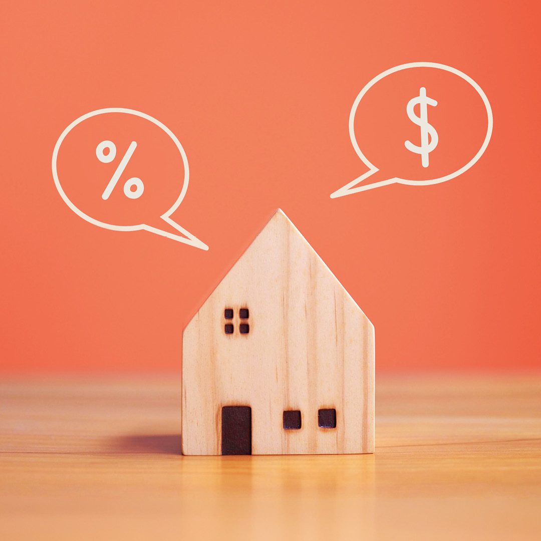 Wooden model house with mortgage rate and dollar sign icons on an orange background. Venture Title & Escrow blog graphic
